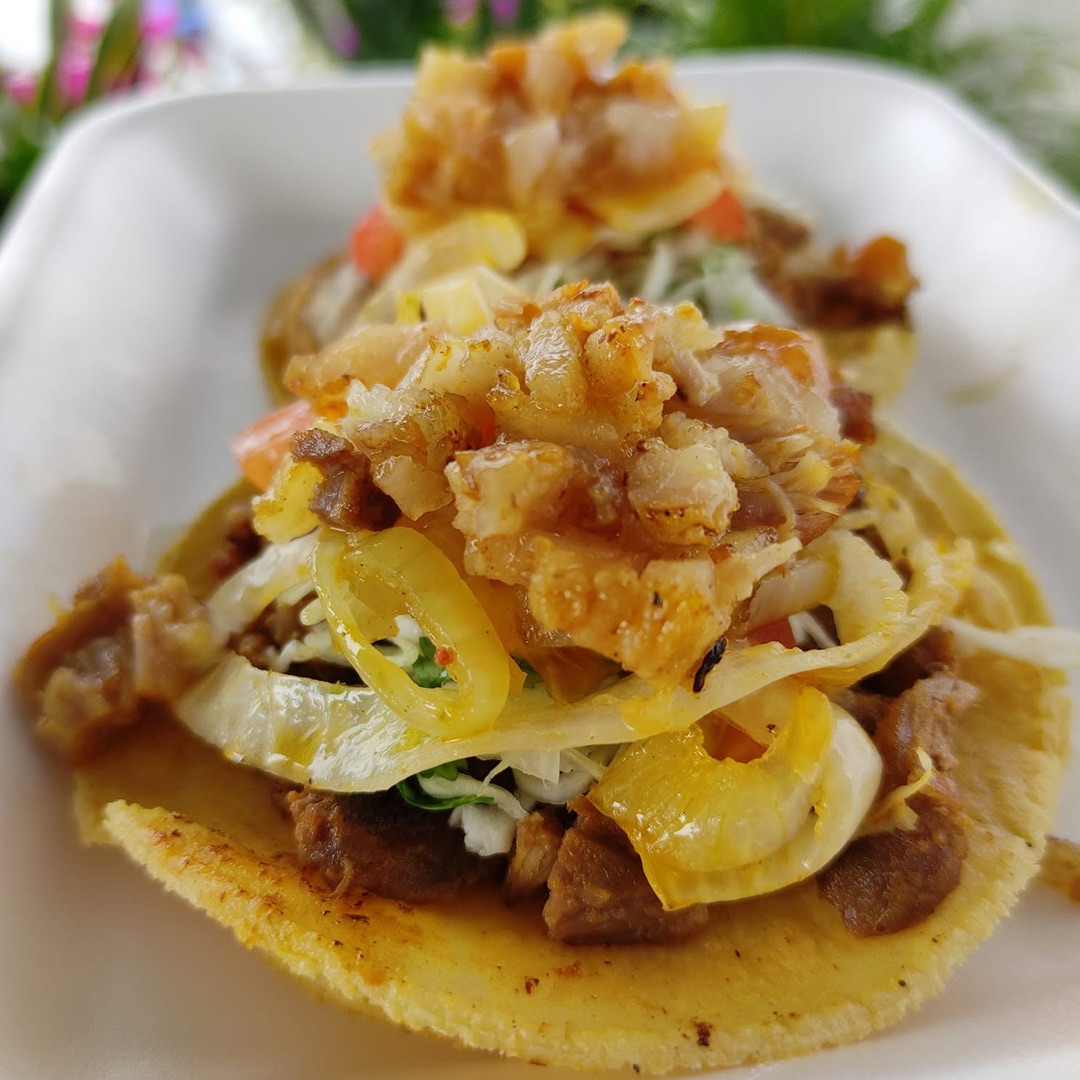 Taco servido con carne, cebolla, col y tomate